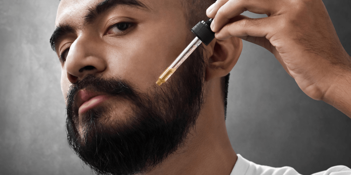 A man applying minoxidil for beard growth.