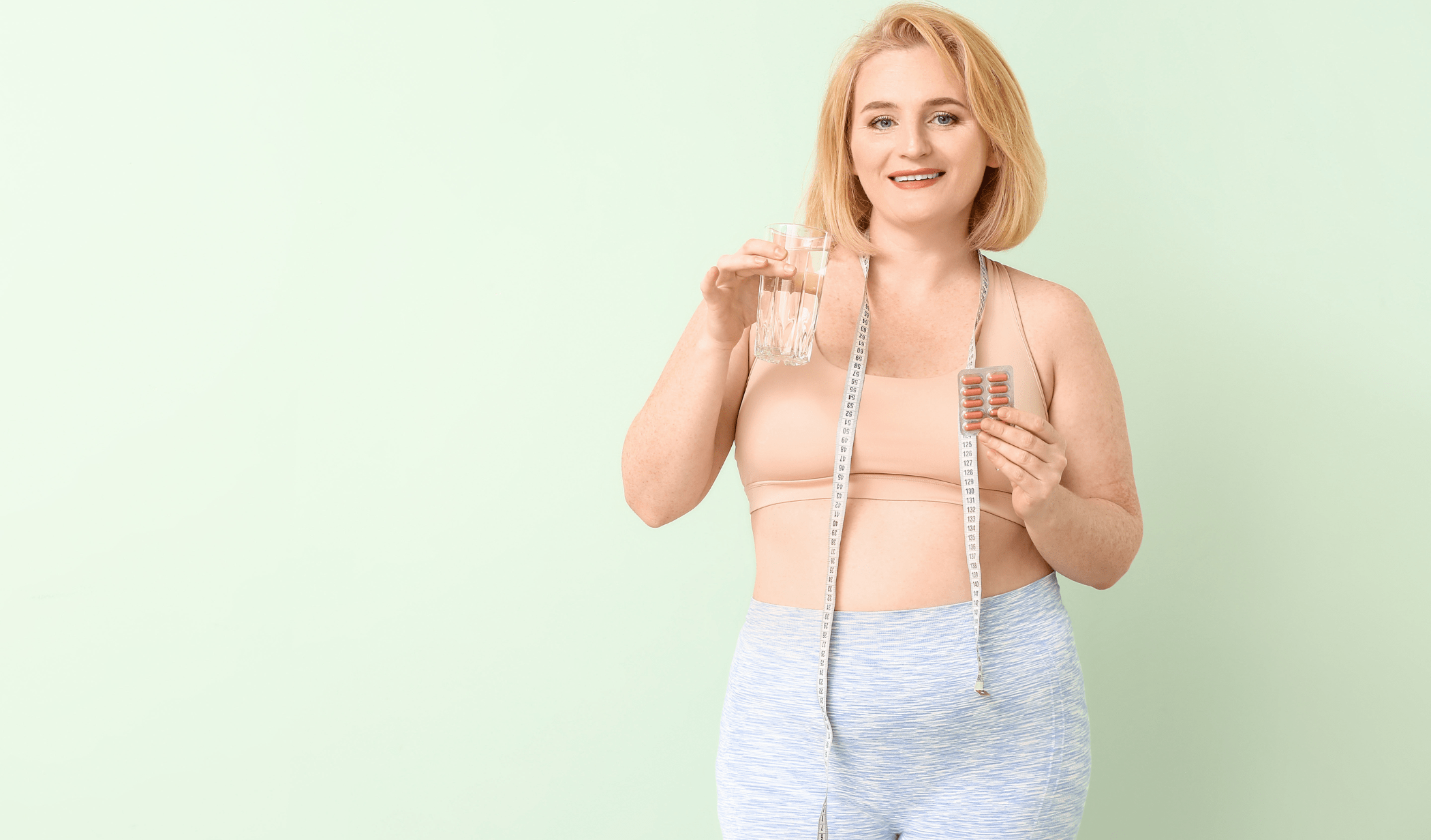 A woman with a tape measure and weight loss pills.