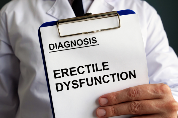 A doctor holding a clipboard that says Diagnosis: Erectile Dysfunction
