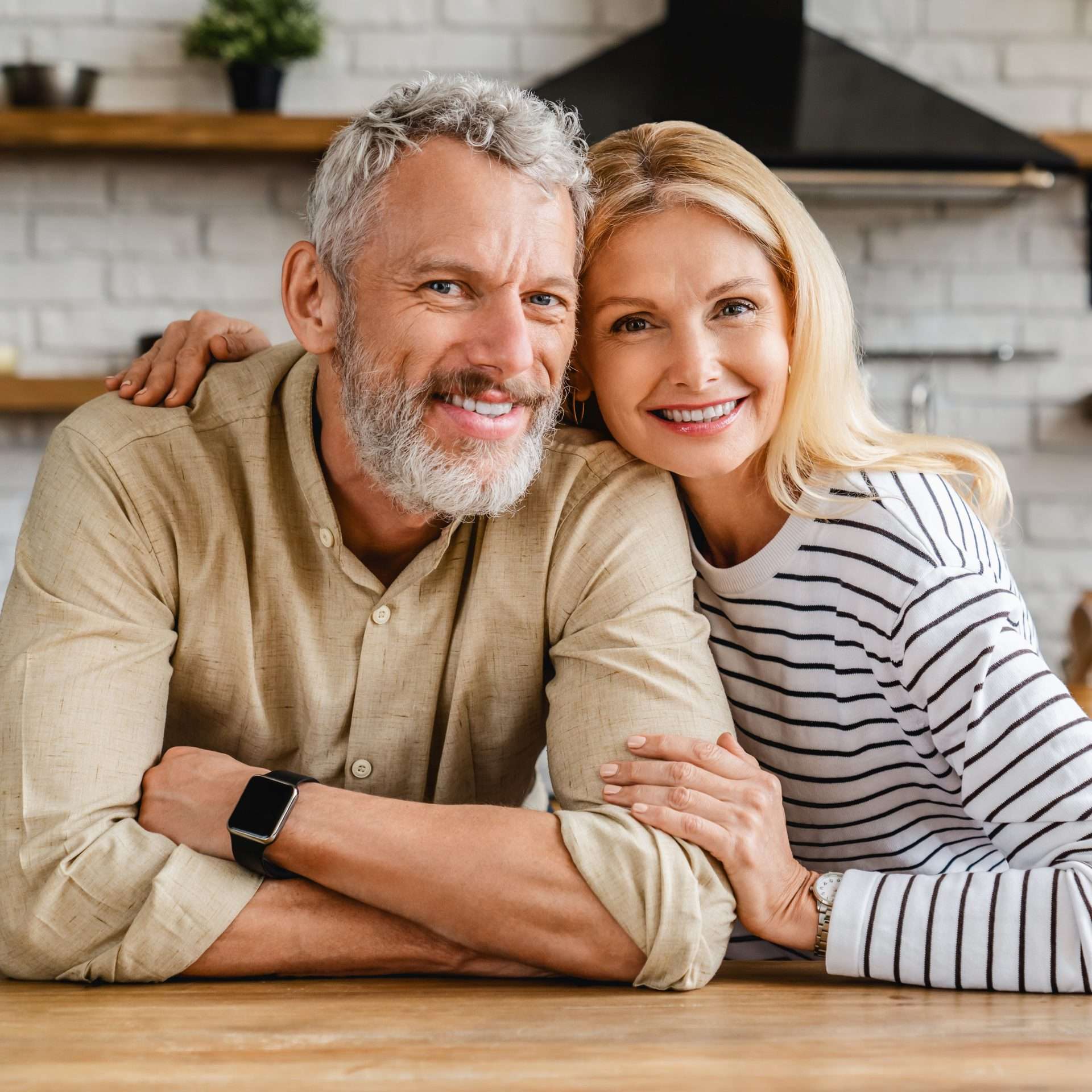 A happy couple together behind a table, embracing