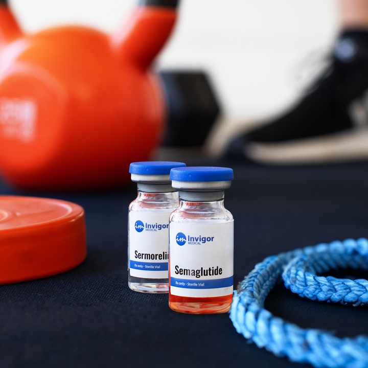 Two vials labeled semaglutide and sermorelin sit on a dark surface with a blue rope, orange weight plate, and orange kettlebell in the background, alongside a blurred athletic shoe—perfect for those looking to buy semaglutide and sermorelin.