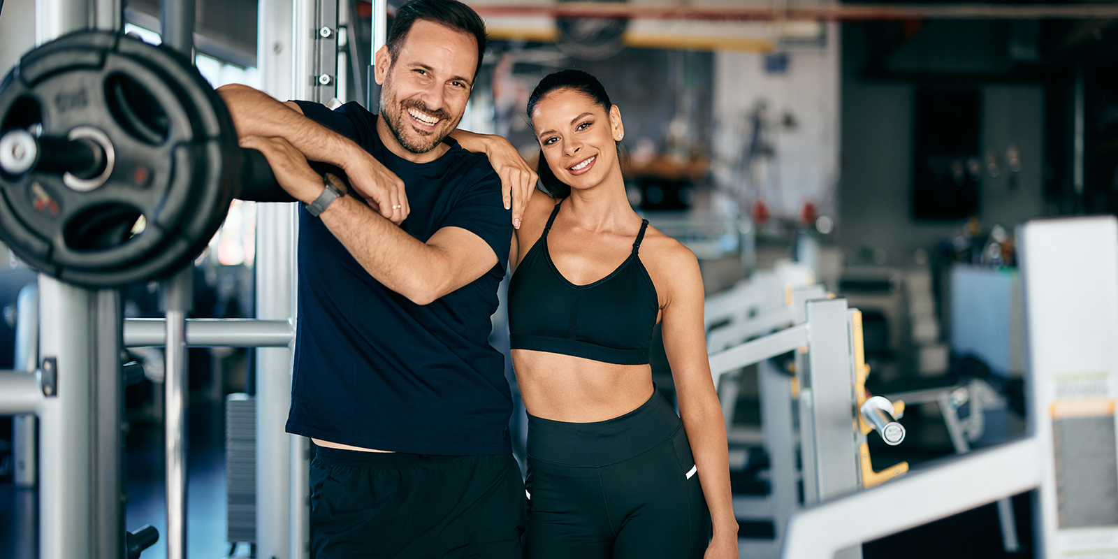 Man and Woman close to eachother in the gym, smiling