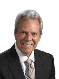 Smiling older man with gray hair wearing a dark suit, white shirt, and patterned tie, posed against a blank background—reflecting the confidence and insight inspired by The People Code.