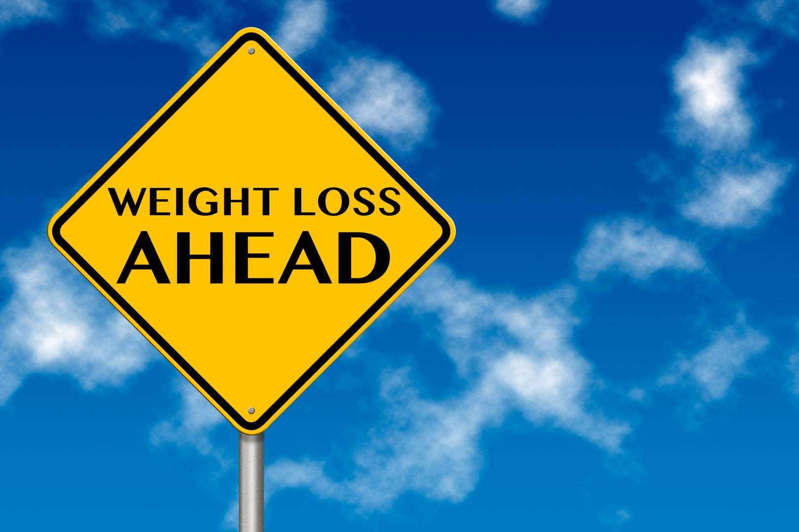 A sign that says weight loss ahead on it