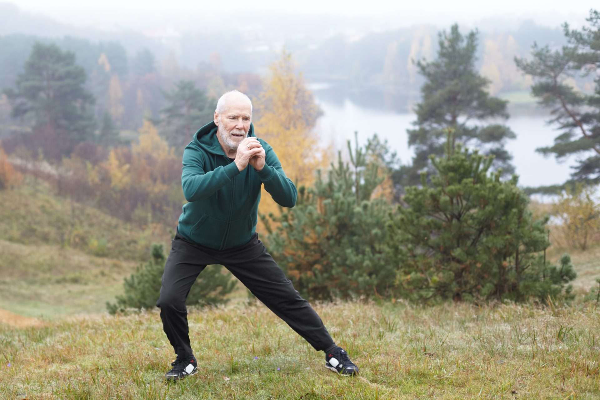 Older male doing a yoga pose outside
