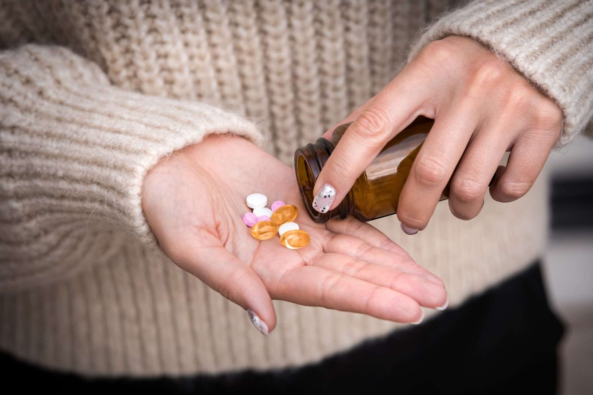 Close up of a woman pouring Vitamin B12 into her hand