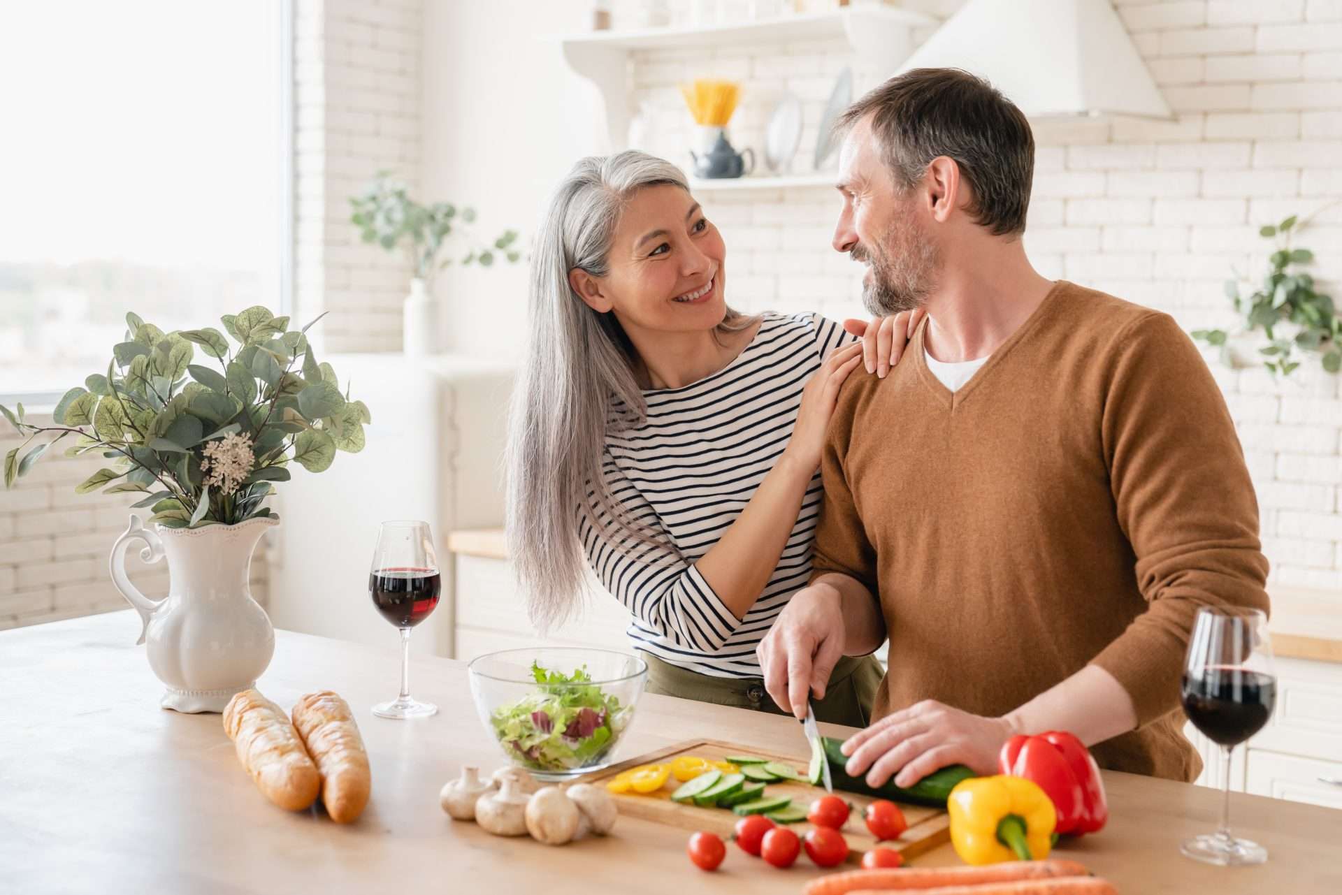 Older couple in the kitchen cutting vegetables