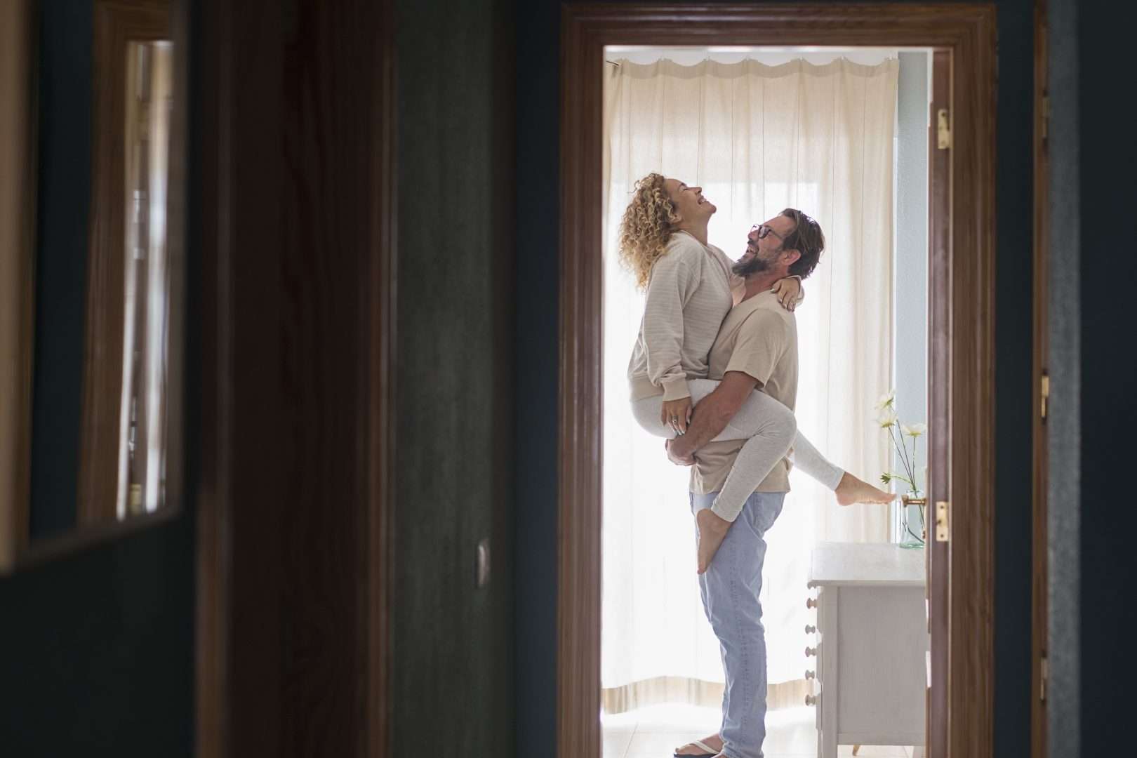 A man holding a woman romantically in the bedroom