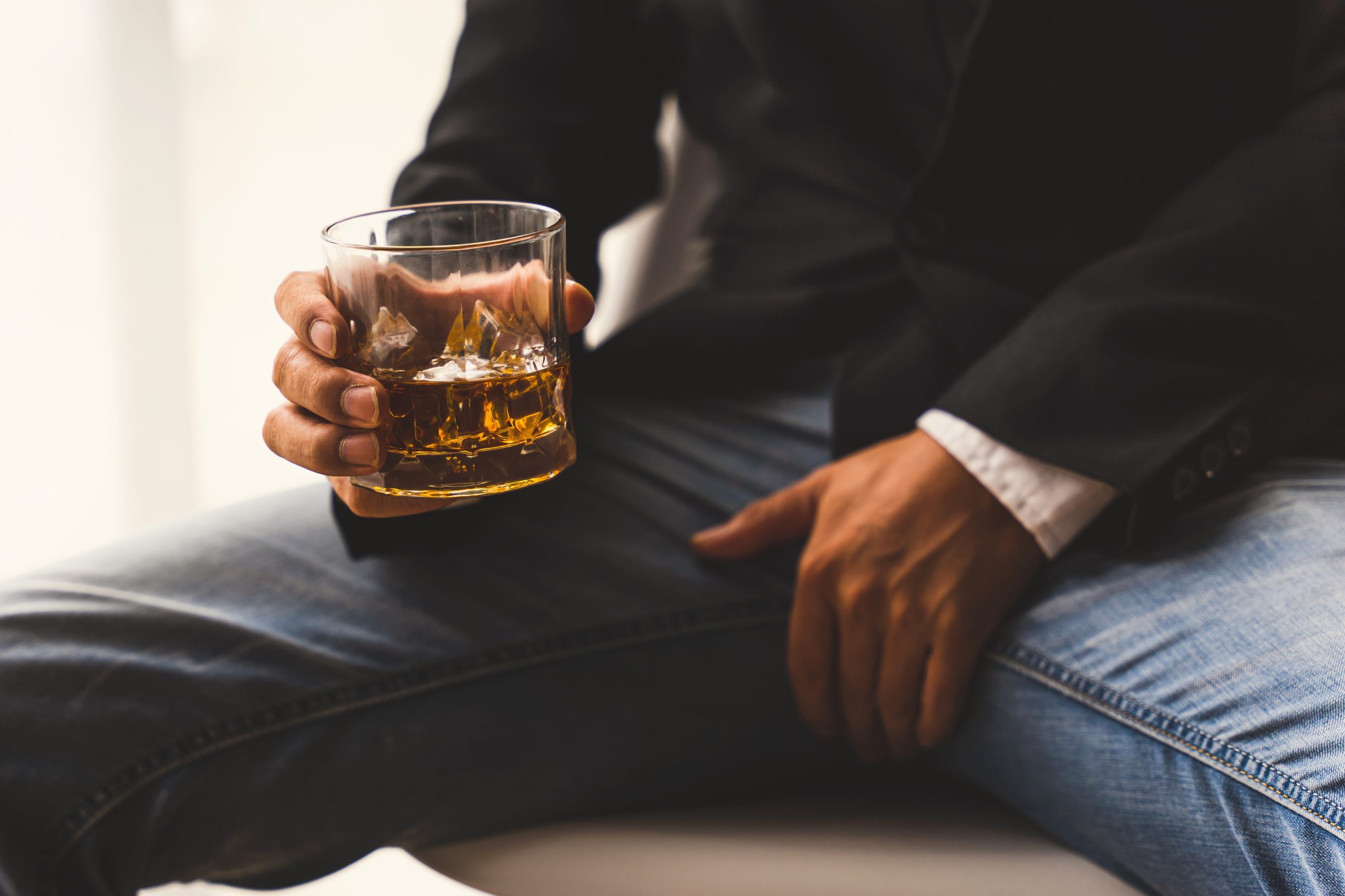 Man holding his junk while holding a glass of alcohol