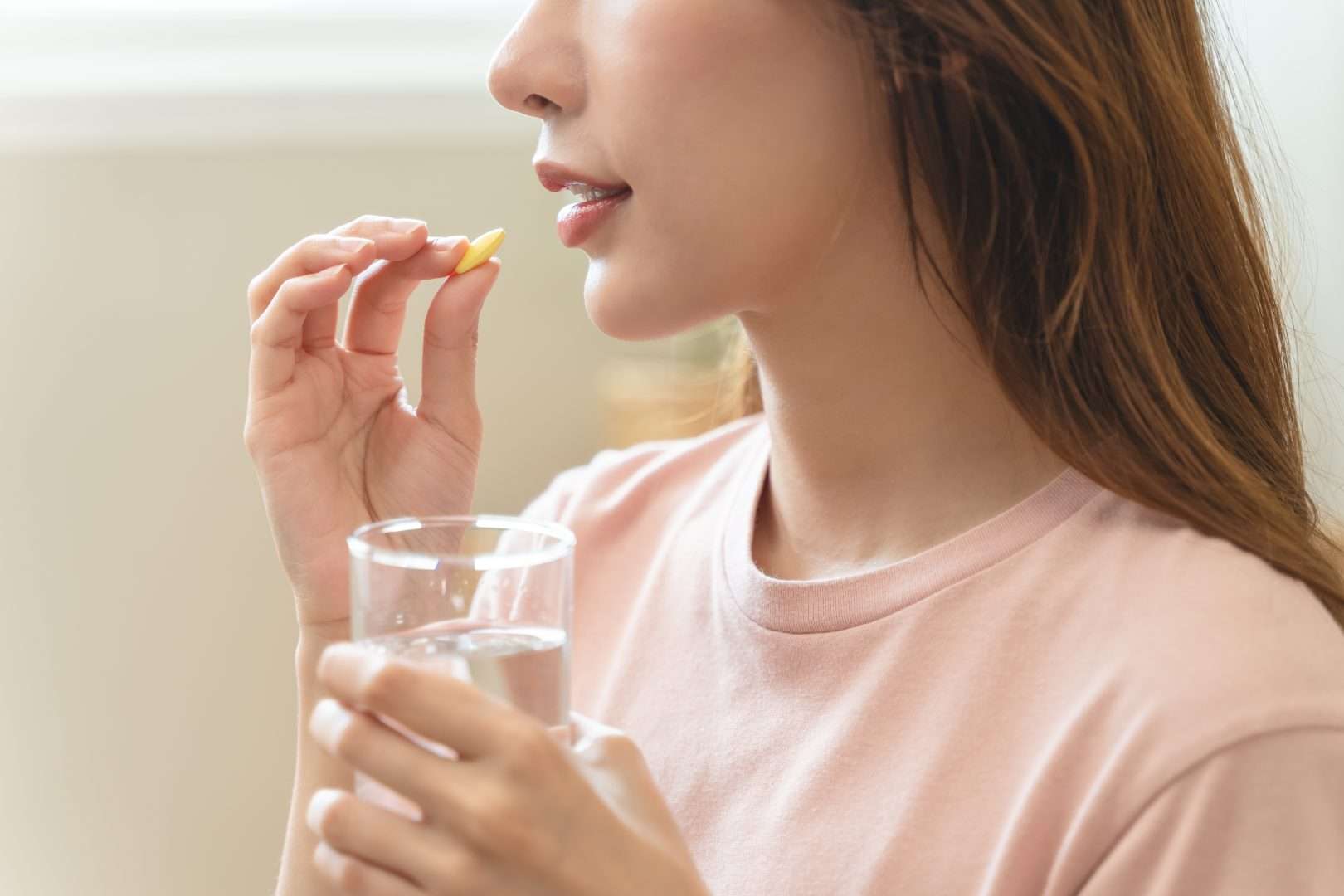 A woman about to take a supplement